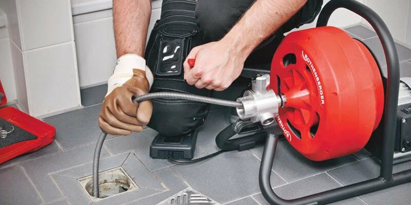 Plumber using a drain-cleaning machine in Fleming Island