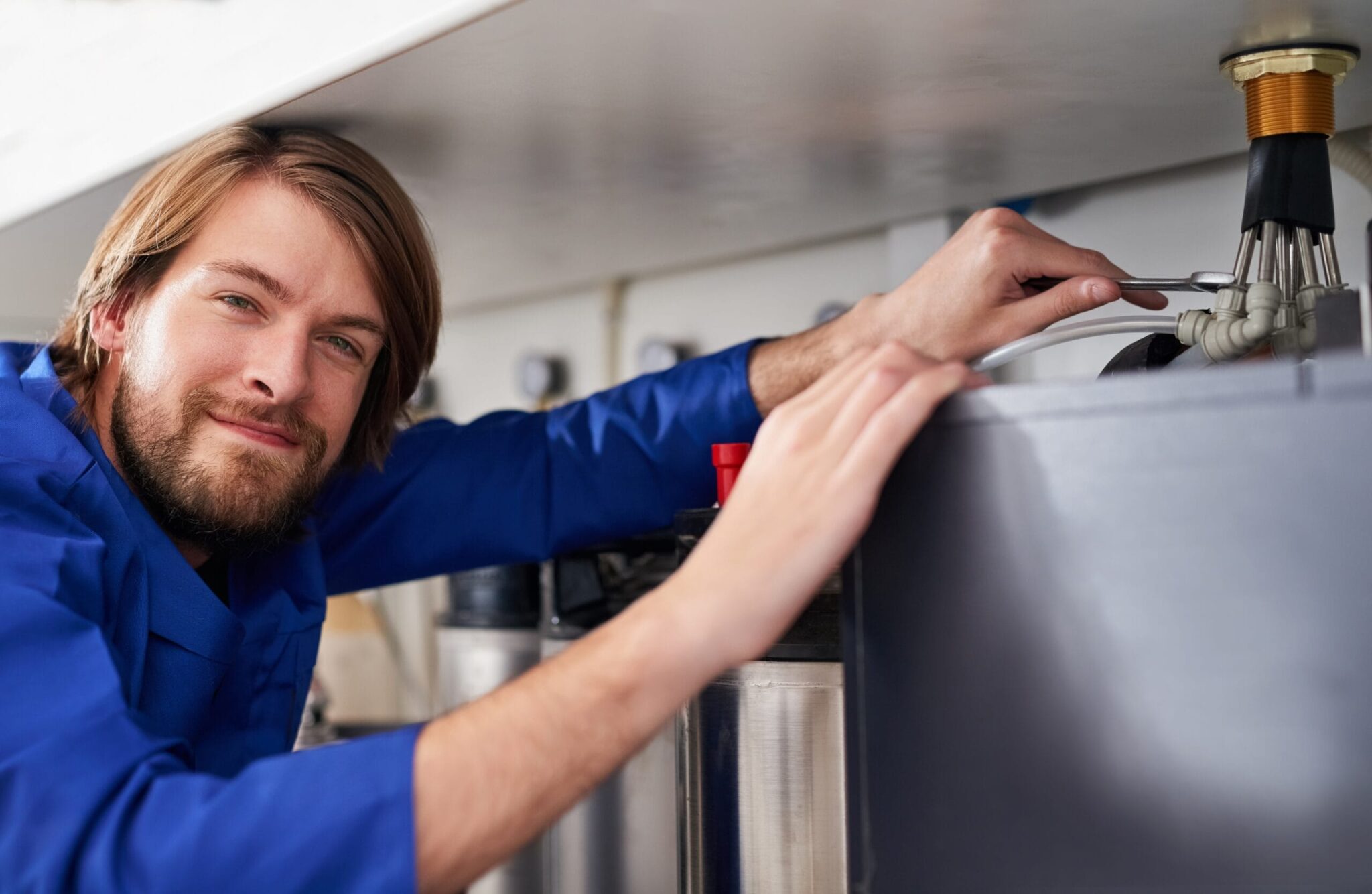 Technician servicing a residential water heater tank in Fleming Island