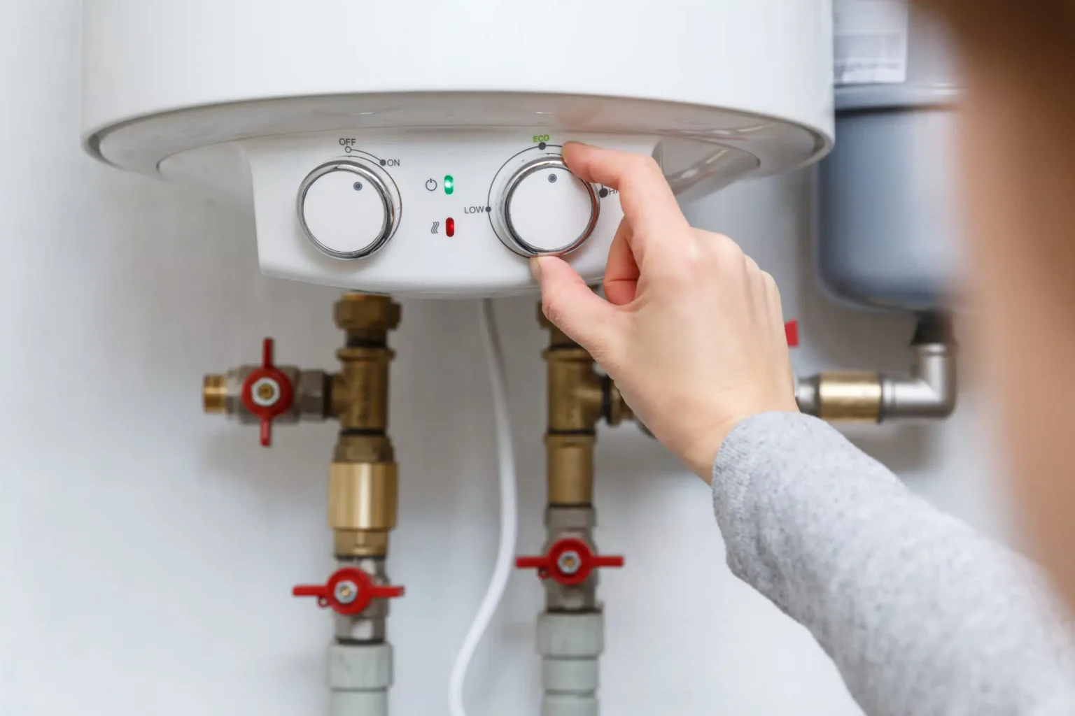 Homeowner adjusting the temperature controls on a water heater in Fleming Island